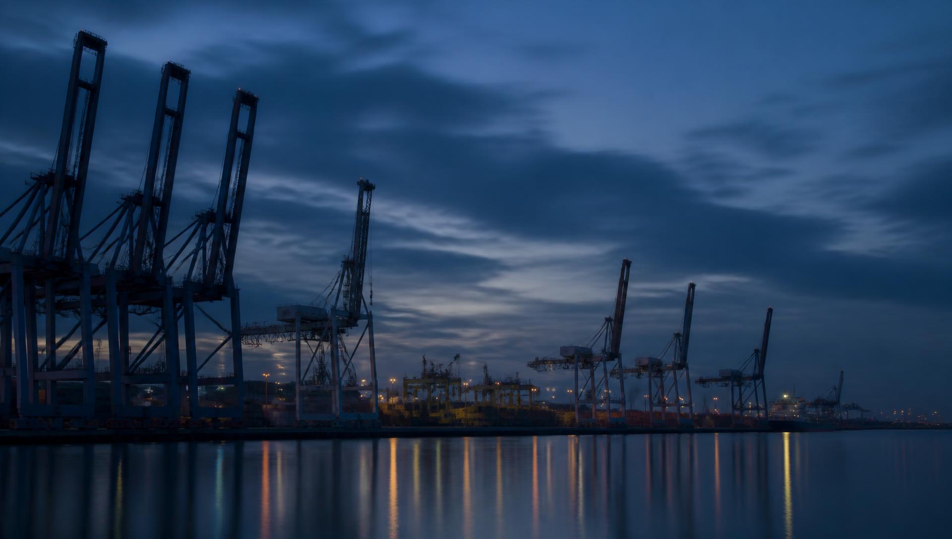 Terminal portuaire avec portiques à conteneurs à l'heure bleue